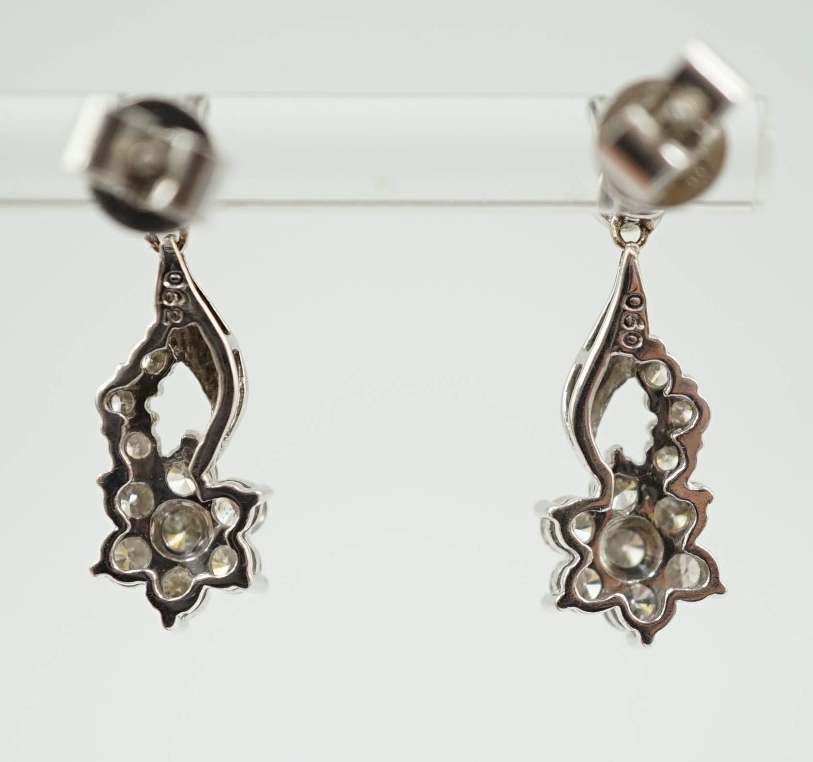 A modern pair of 18k white gold and diamond cluster ear studs, each modelled as a flower with stem